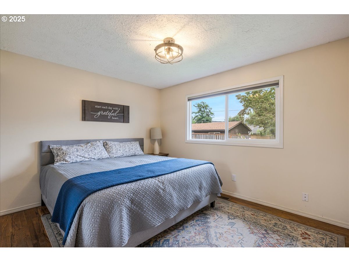 2604 Southeast 176th Place Portland, OR 97236 - Photo 18 of 27 a bedroom with a bed and a painting on the wall