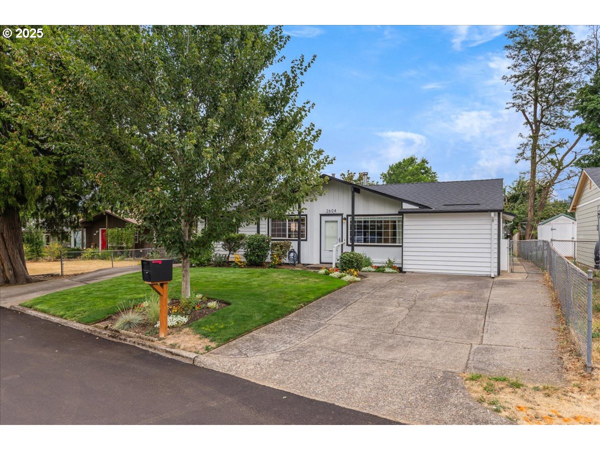 2604 Southeast 176th Place Portland, OR 97236 - Photo 2 of 27 a front view of a house with a yard and garage