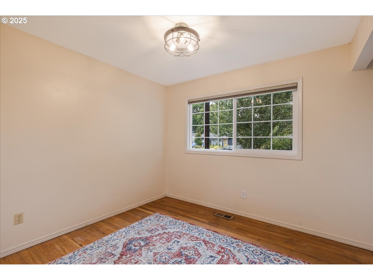 2604 Southeast 176th Place Portland, OR 97236 - Photo 21 of 27 an empty room with wooden floor and windows