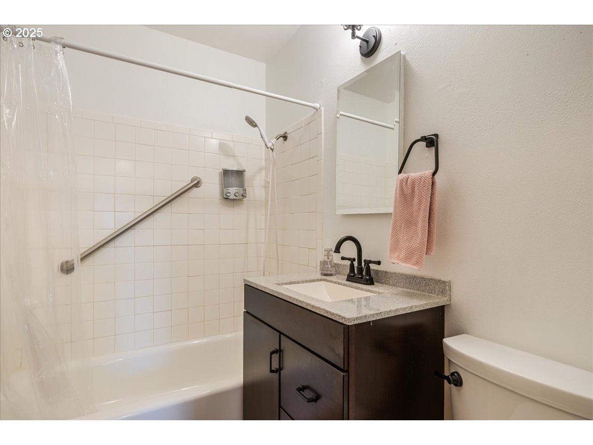 2604 Southeast 176th Place Portland, OR 97236 - Photo 22 of 27 a bathroom with a sink vanity granite tub shower and mirror