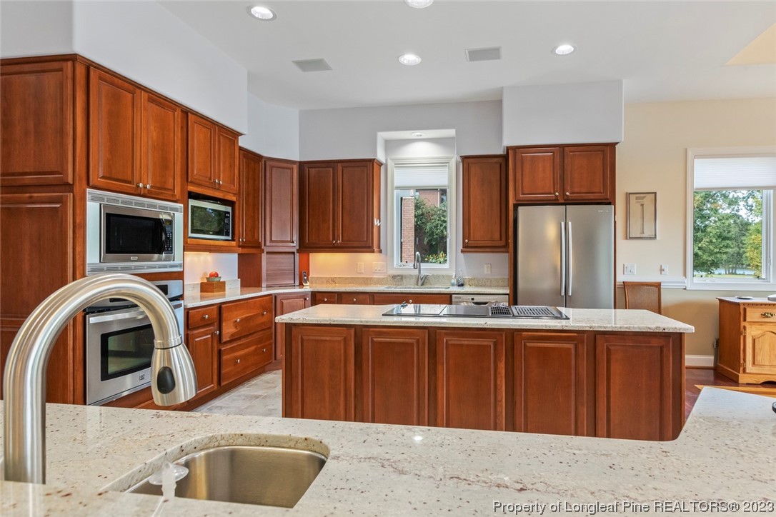 4 The Pointe Sanford, NC 27332 - Photo 17 of 50 a kitchen with stainless steel appliances granite countertop a sink a stove and a refrigerator