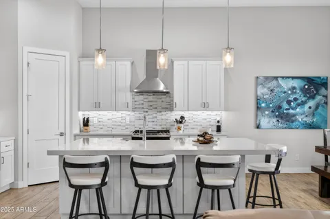 a kitchen with granite countertop a dining table chairs and white cabinets