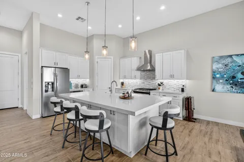 a kitchen with kitchen island a dining table and chairs