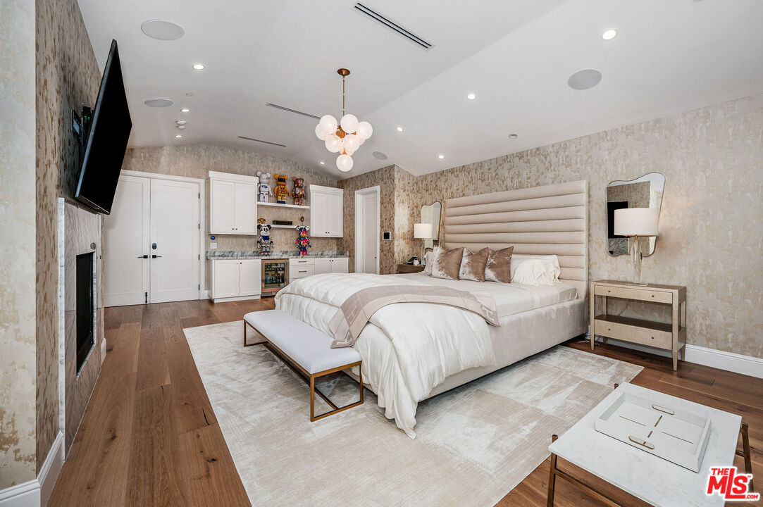 4421 Haskell Avenue Encino, CA 91436 - Photo 16 of 32 a spacious bedroom with a bed and a flat screen tv