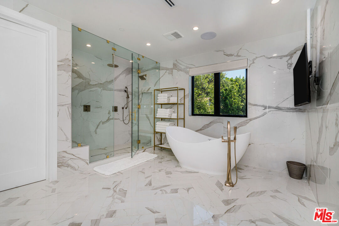 4421 Haskell Avenue Encino, CA 91436 - Photo 18 of 32 a bathroom with a tub shower and mirror
