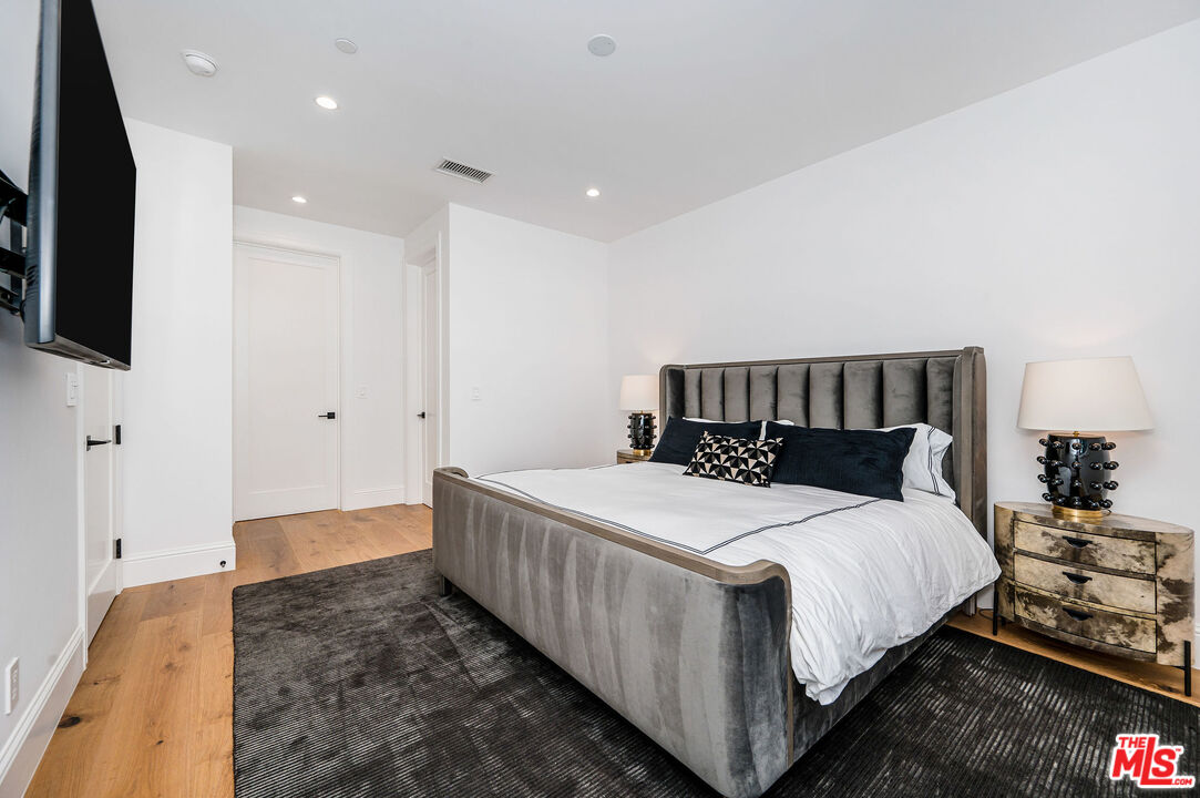 4421 Haskell Avenue Encino, CA 91436 - Photo 21 of 32 a bedroom with a bed and a flat screen tv