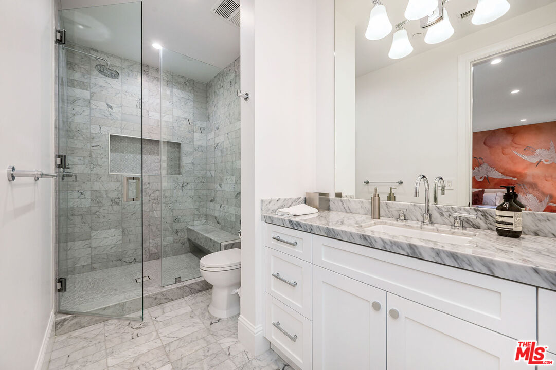 4421 Haskell Avenue Encino, CA 91436 - Photo 23 of 32 a bathroom with a granite countertop sink a toilet and a shower