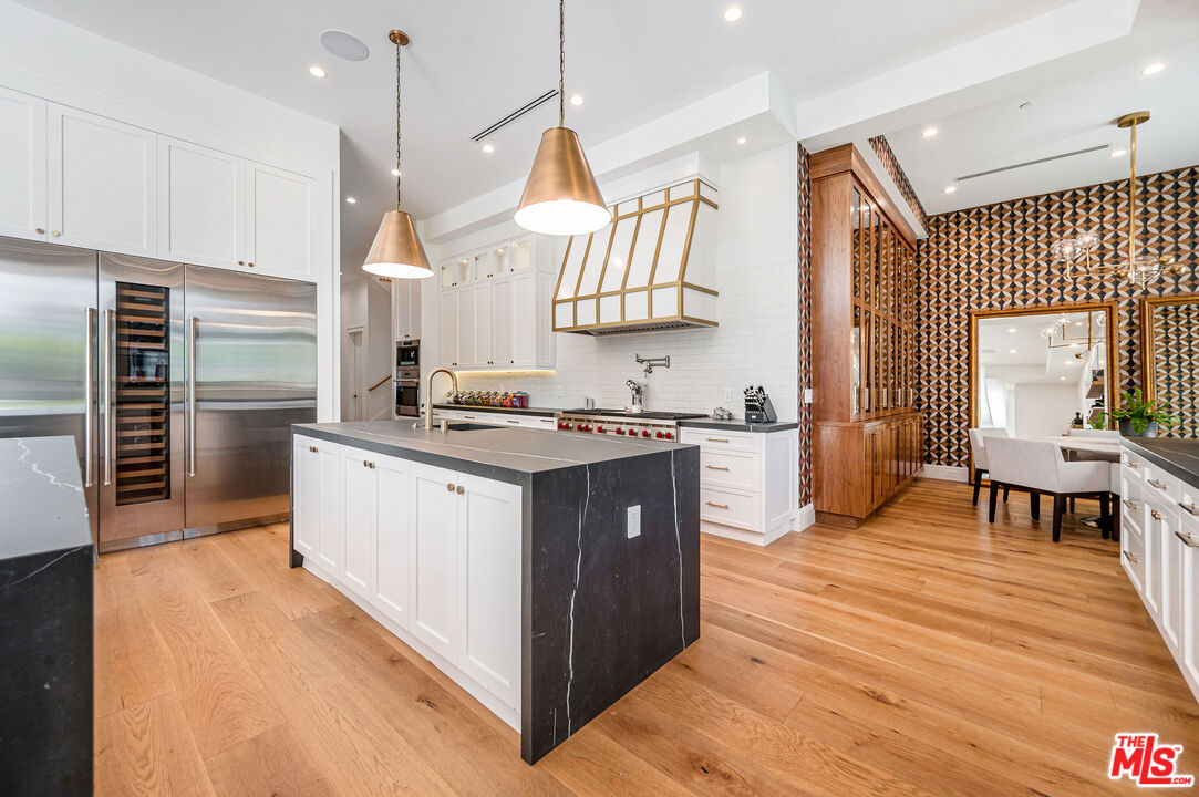 4421 Haskell Avenue Encino, CA 91436 - Photo 10 of 32 a kitchen with stainless steel appliances granite countertop a sink a stove and a wooden floors