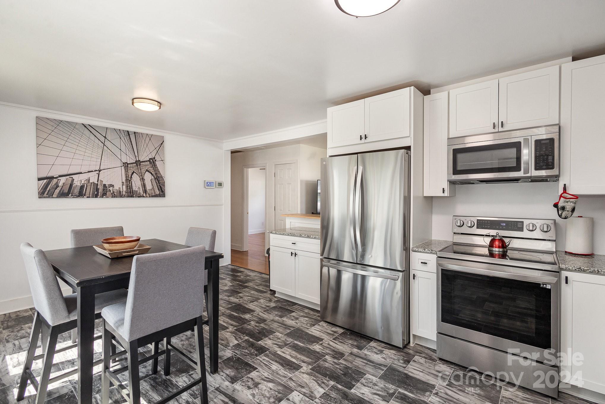 4431 Westridge Drive Charlotte, NC 28208 - Photo 9 of 24 a kitchen with stainless steel appliances a stove a refrigerator microwave a dining table and chairs