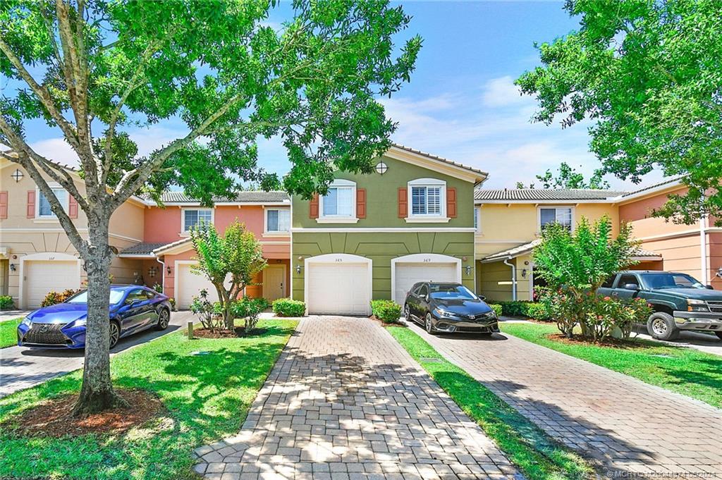 365 Southeast Bloxham Way Stuart, FL 34997 - Photo 1 of 27 a front view of a house with a garden