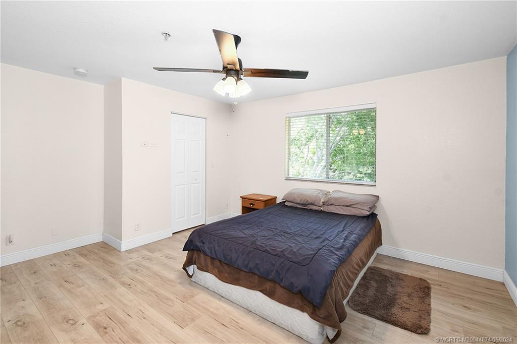 365 Southeast Bloxham Way Stuart, FL 34997 - Photo 11 of 27 a bedroom with a bed and wooden floor