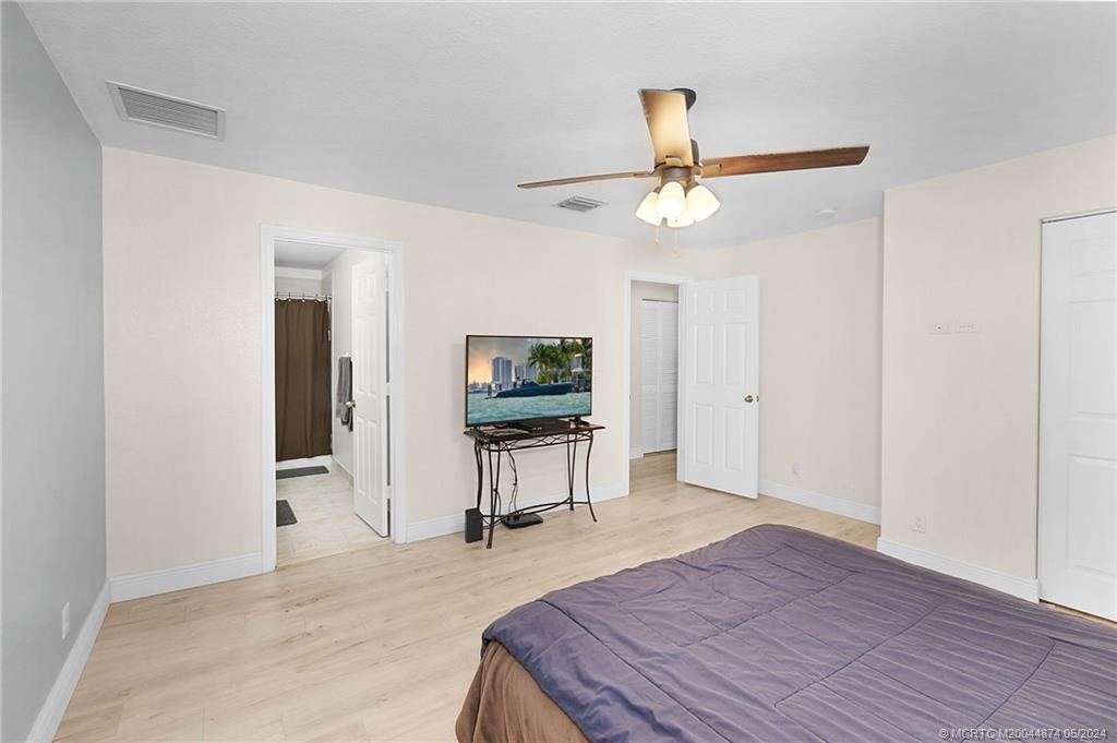 365 Southeast Bloxham Way Stuart, FL 34997 - Photo 13 of 27 a bedroom with furniture and a ceiling fan