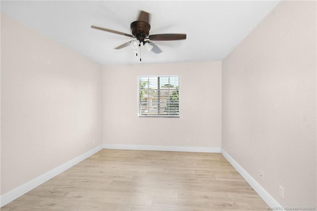 365 Southeast Bloxham Way Stuart, FL 34997 - Photo 17 of 27 a view of empty room with wooden floor and fan