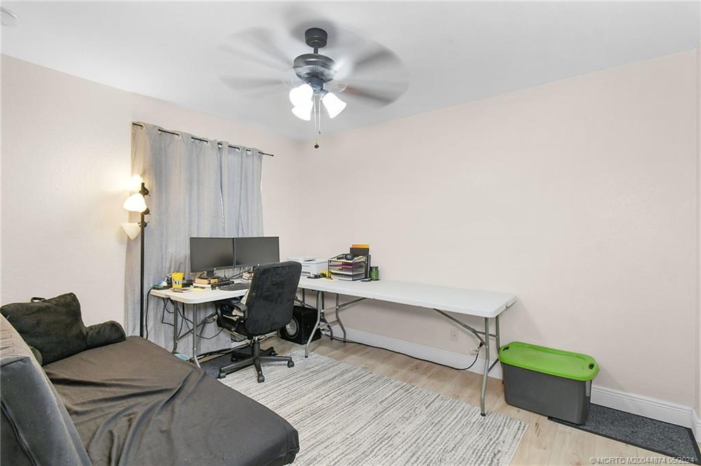 365 Southeast Bloxham Way Stuart, FL 34997 - Photo 18 of 27 a view of a workspace with furniture and a chandelier fan