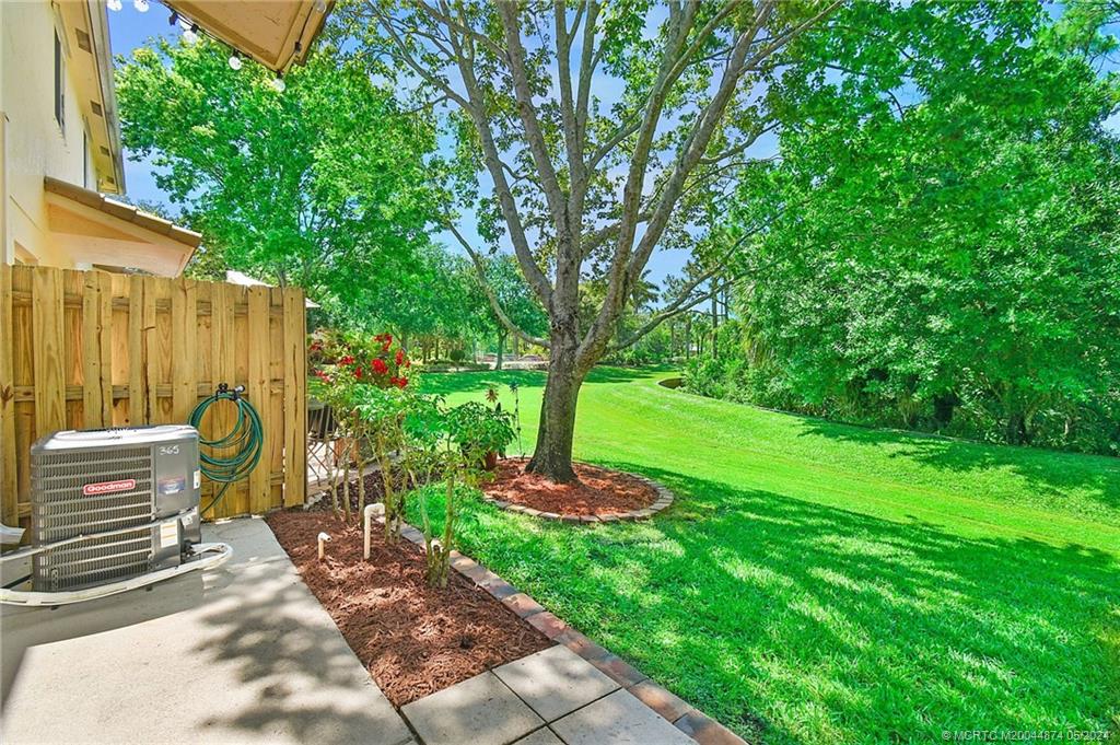 365 Southeast Bloxham Way Stuart, FL 34997 - Photo 21 of 27 a view of a backyard with plants and a tree