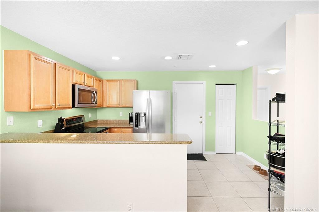 365 Southeast Bloxham Way Stuart, FL 34997 - Photo 8 of 27 a kitchen with stainless steel appliances granite countertop a refrigerator and a sink
