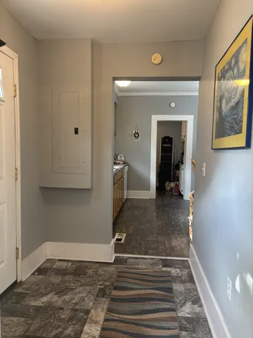 a view of a hallway with wooden floor and a living room