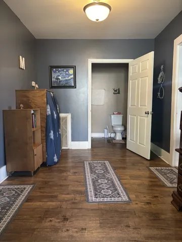 a view of a livingroom with wooden floor and furniture