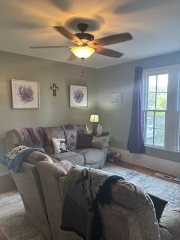 a living room with a bed furniture and a window