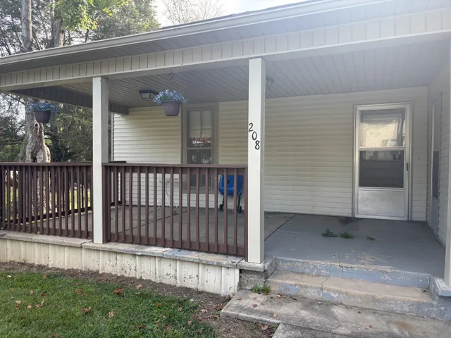 a view of a house with a small yard and wooden fence and floor to ceiling window
