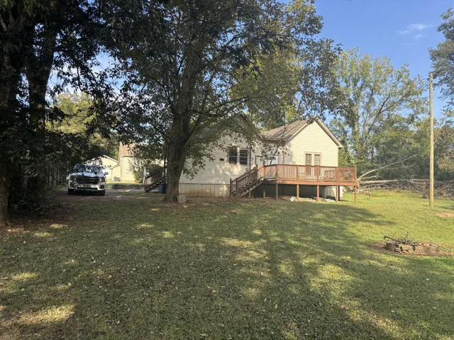 a view of large trees with a yard