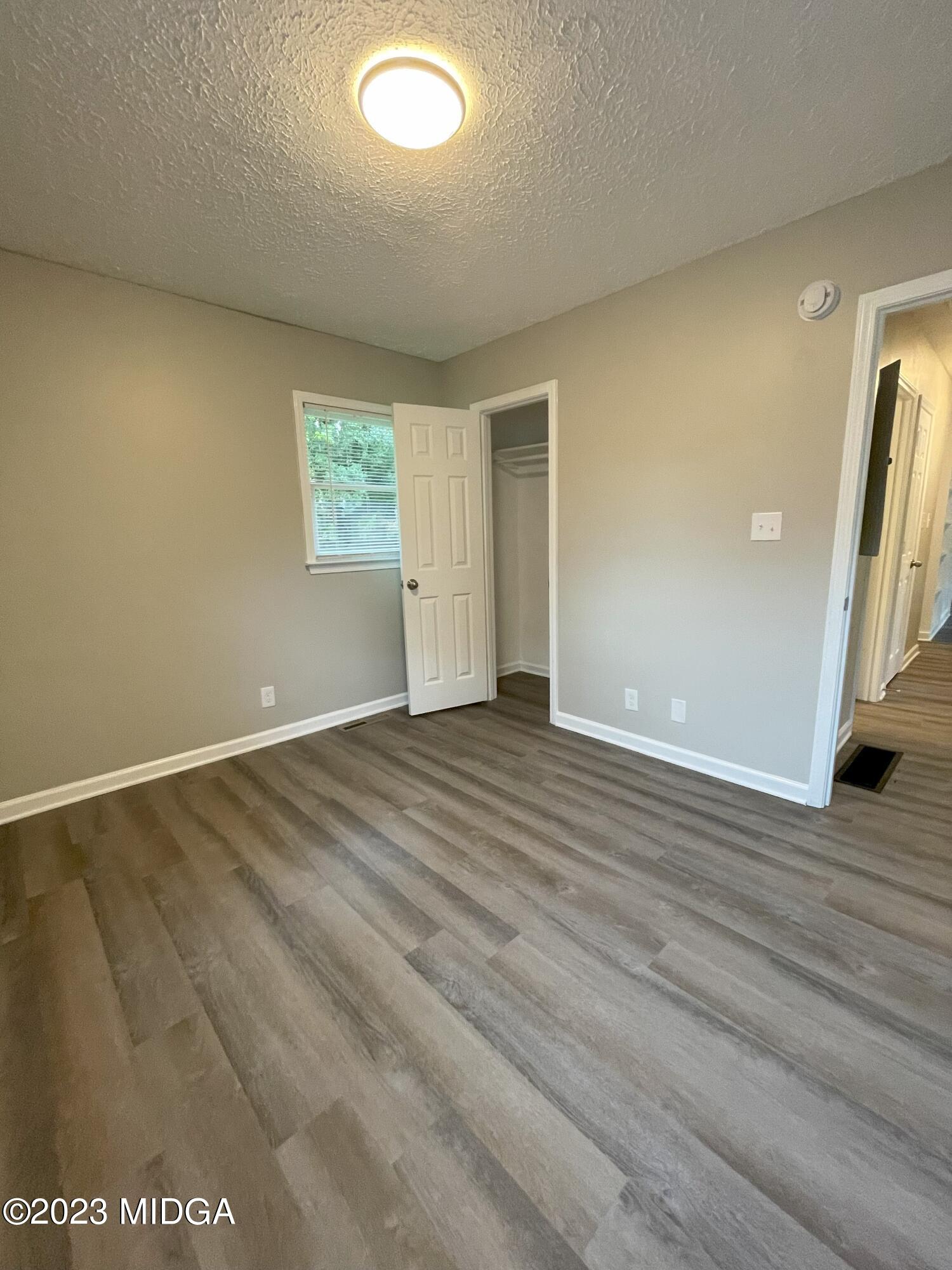 1437 Canterbury Road Macon, GA 31206 - Photo 16 of 18 an empty room with wooden floor and windows