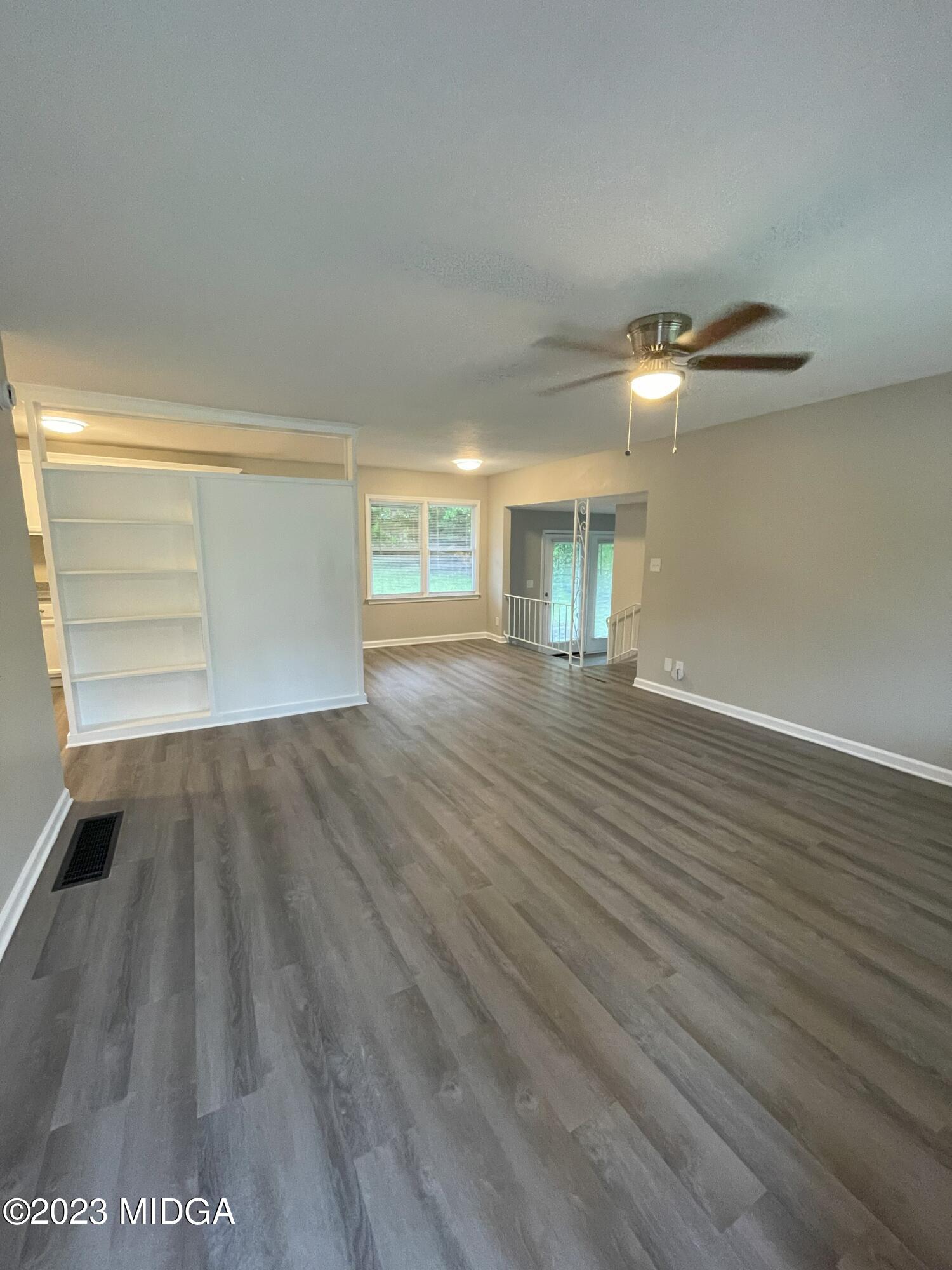 1437 Canterbury Road Macon, GA 31206 - Photo 2 of 18 an empty room with wooden floor and windows