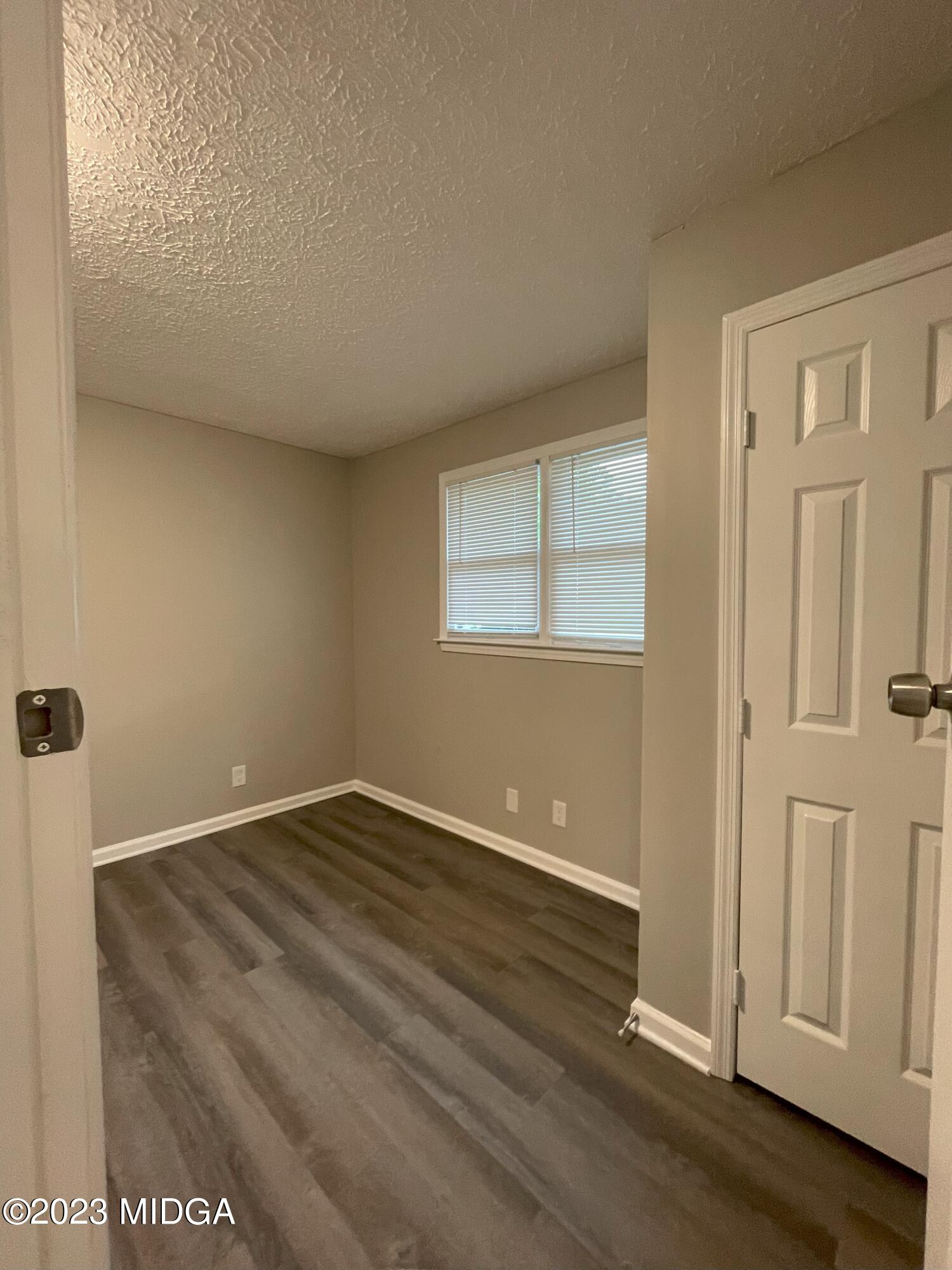 1437 Canterbury Road Macon, GA 31206 - Photo 4 of 18 an empty room with wooden floor and windows