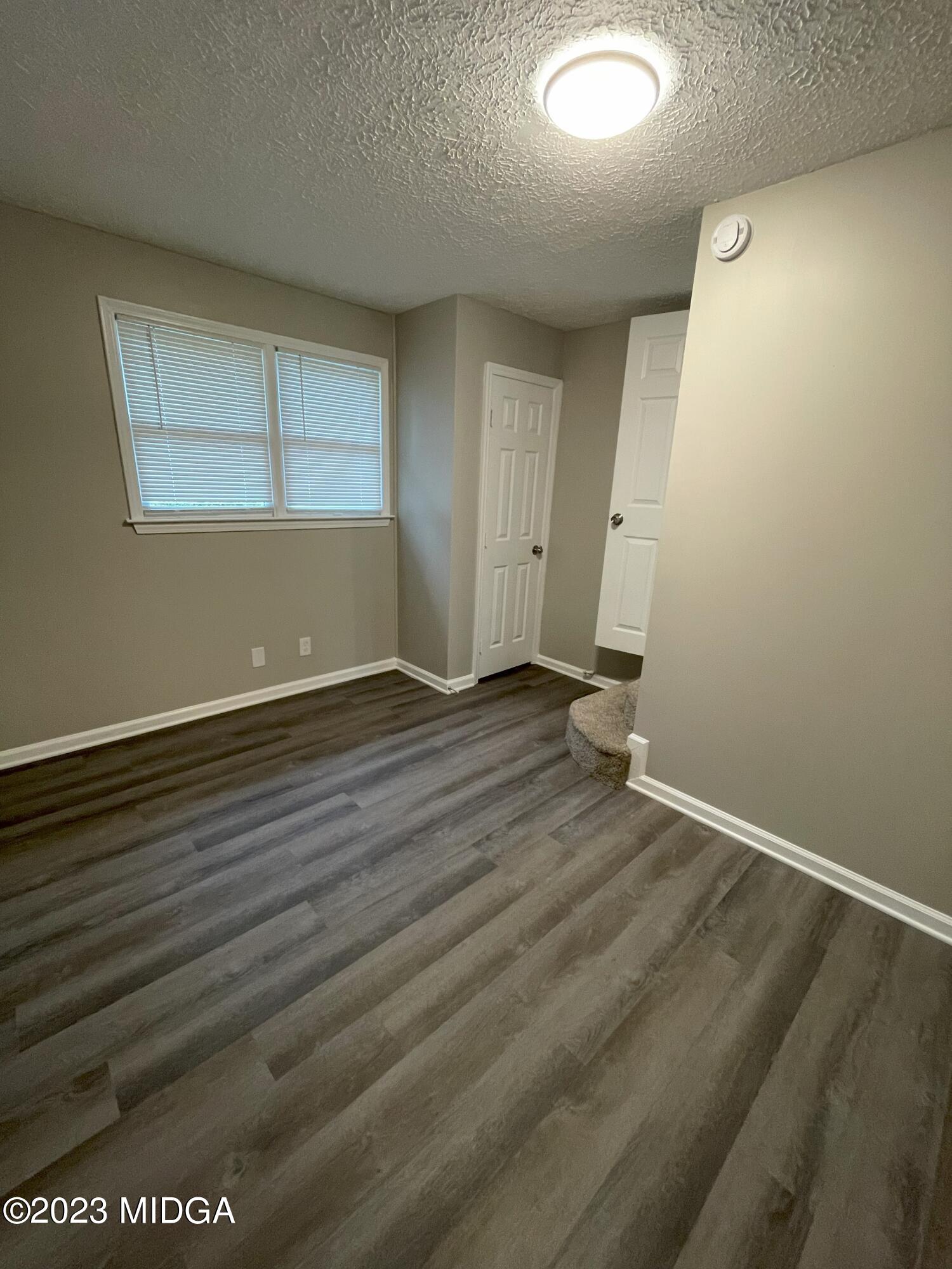 1437 Canterbury Road Macon, GA 31206 - Photo 5 of 18 an empty room with wooden floor and windows
