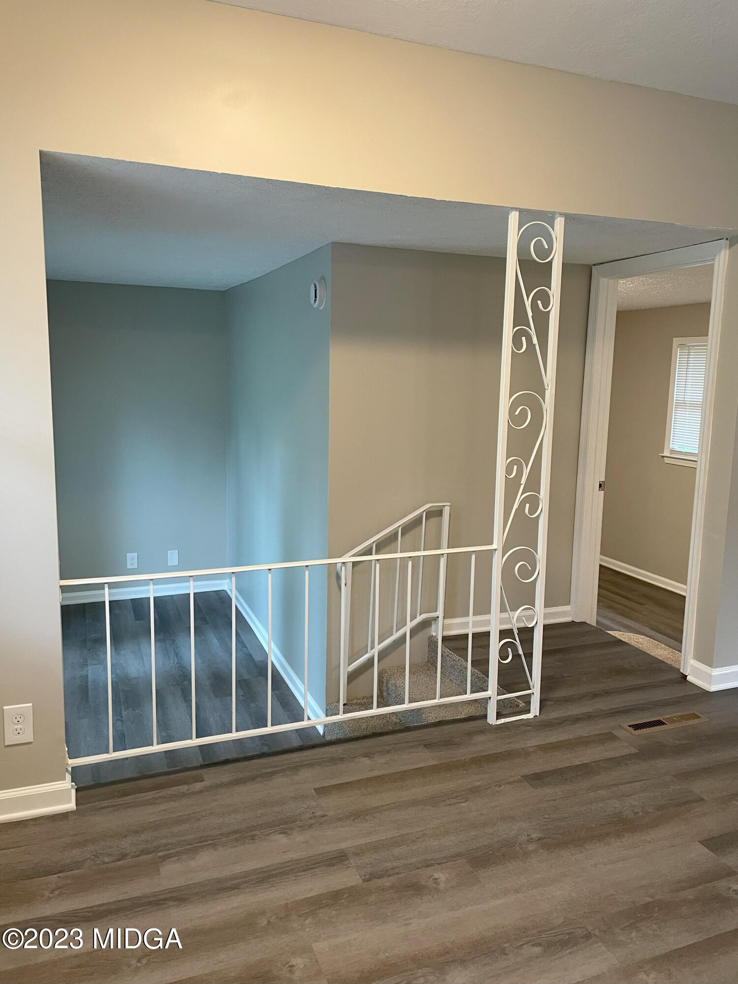 1437 Canterbury Road Macon, GA 31206 - Photo 6 of 18 an empty room with wooden floor and windows