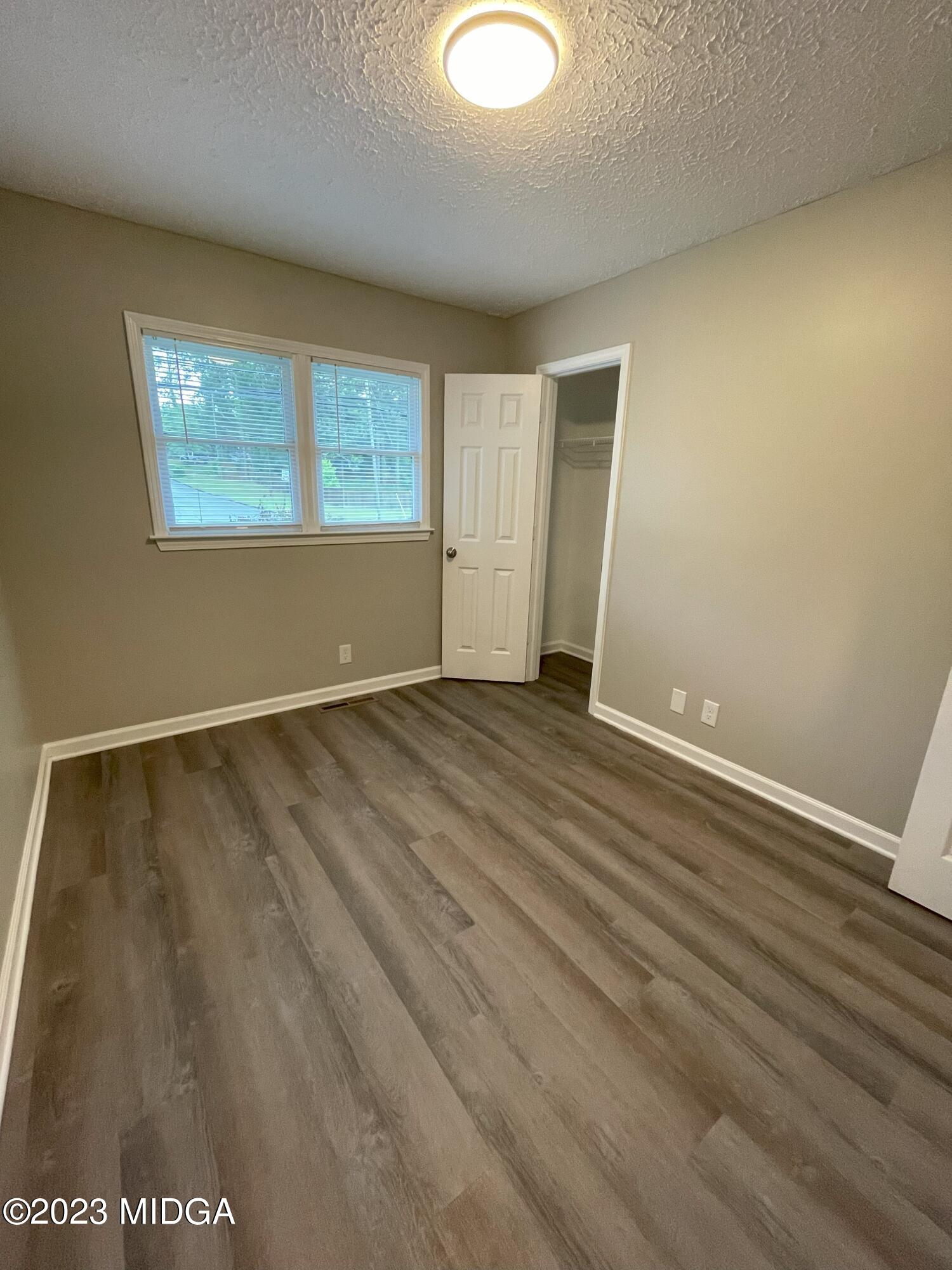 1437 Canterbury Road Macon, GA 31206 - Photo 10 of 18 an empty room with wooden floor and windows
