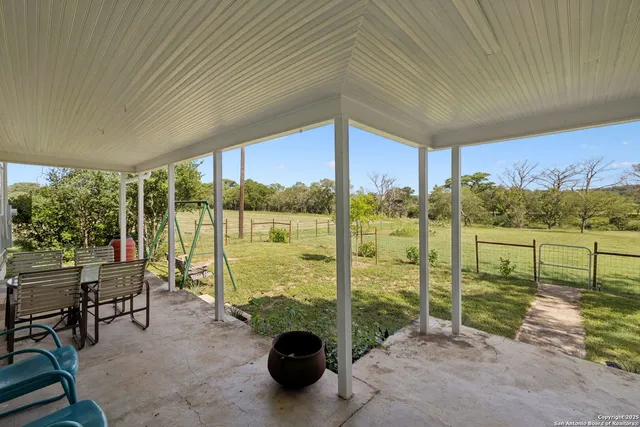 a view of a patio with a table chairs and backyard