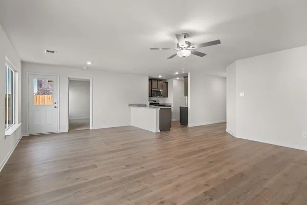 a view of a kitchen with wooden floor and a ceiling fan