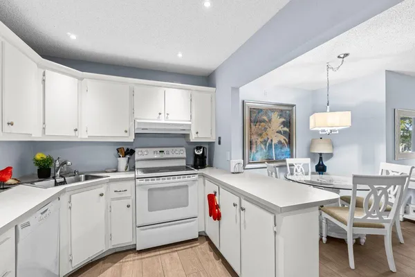 a kitchen with white cabinets and white appliances