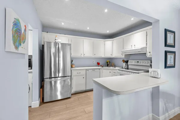 a kitchen with a refrigerator a stove top oven a sink and cabinets