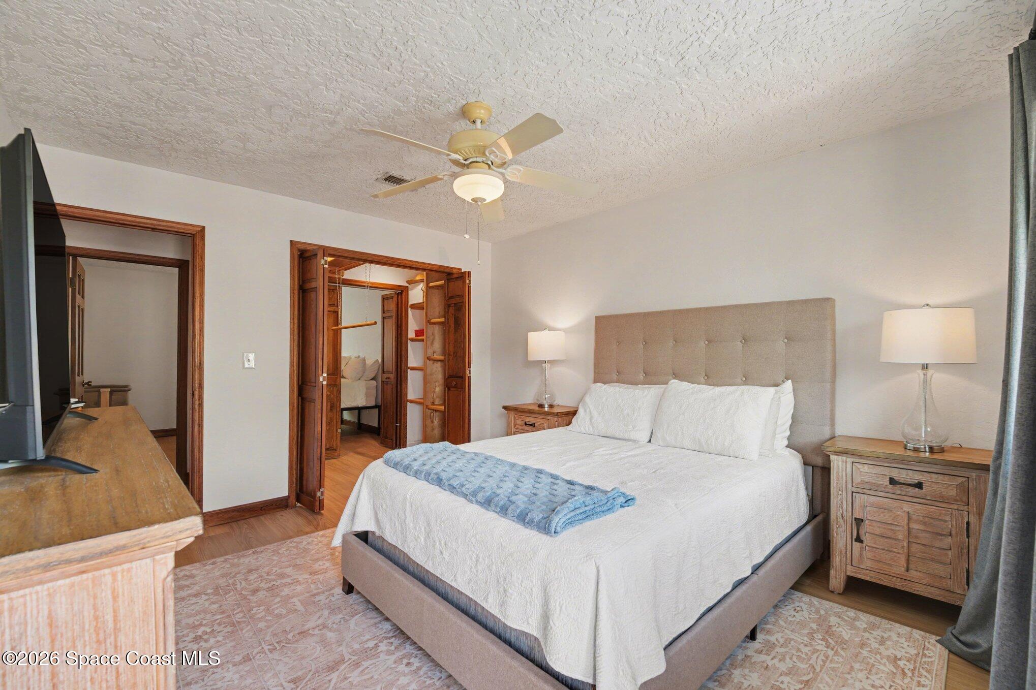 568 Rio Casa Drive North Indialantic, FL 32903 - Photo 19 of 45 a bedroom with a large bed and a chandelier