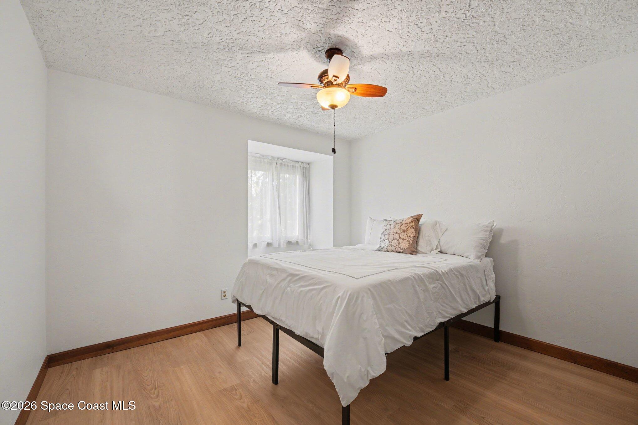 568 Rio Casa Drive North Indialantic, FL 32903 - Photo 20 of 45 a bedroom with a bed and a chandelier