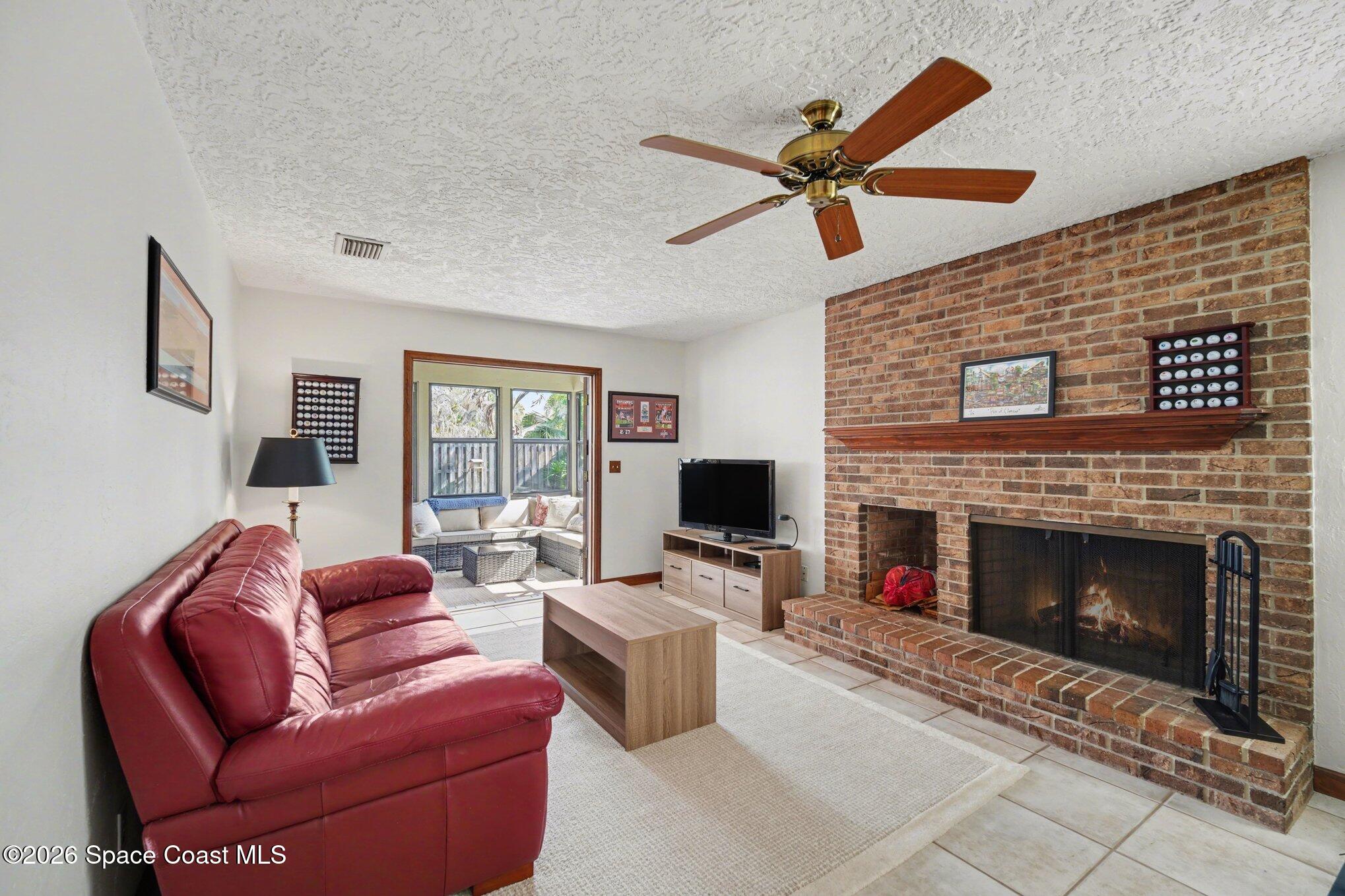 568 Rio Casa Drive North Indialantic, FL 32903 - Photo 26 of 45 a living room with furniture a fireplace and a flat screen tv