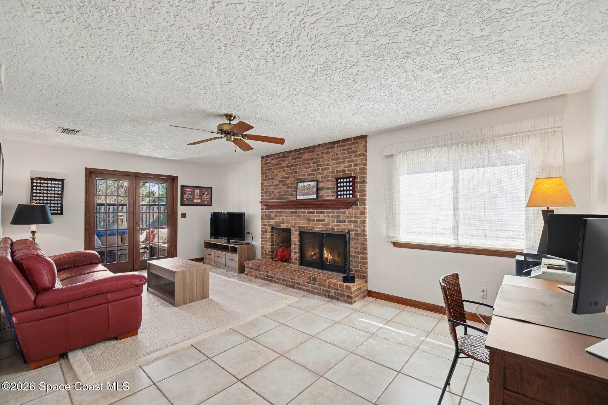 568 Rio Casa Drive North Indialantic, FL 32903 - Photo 27 of 45 a living room with furniture a fireplace and a flat screen tv