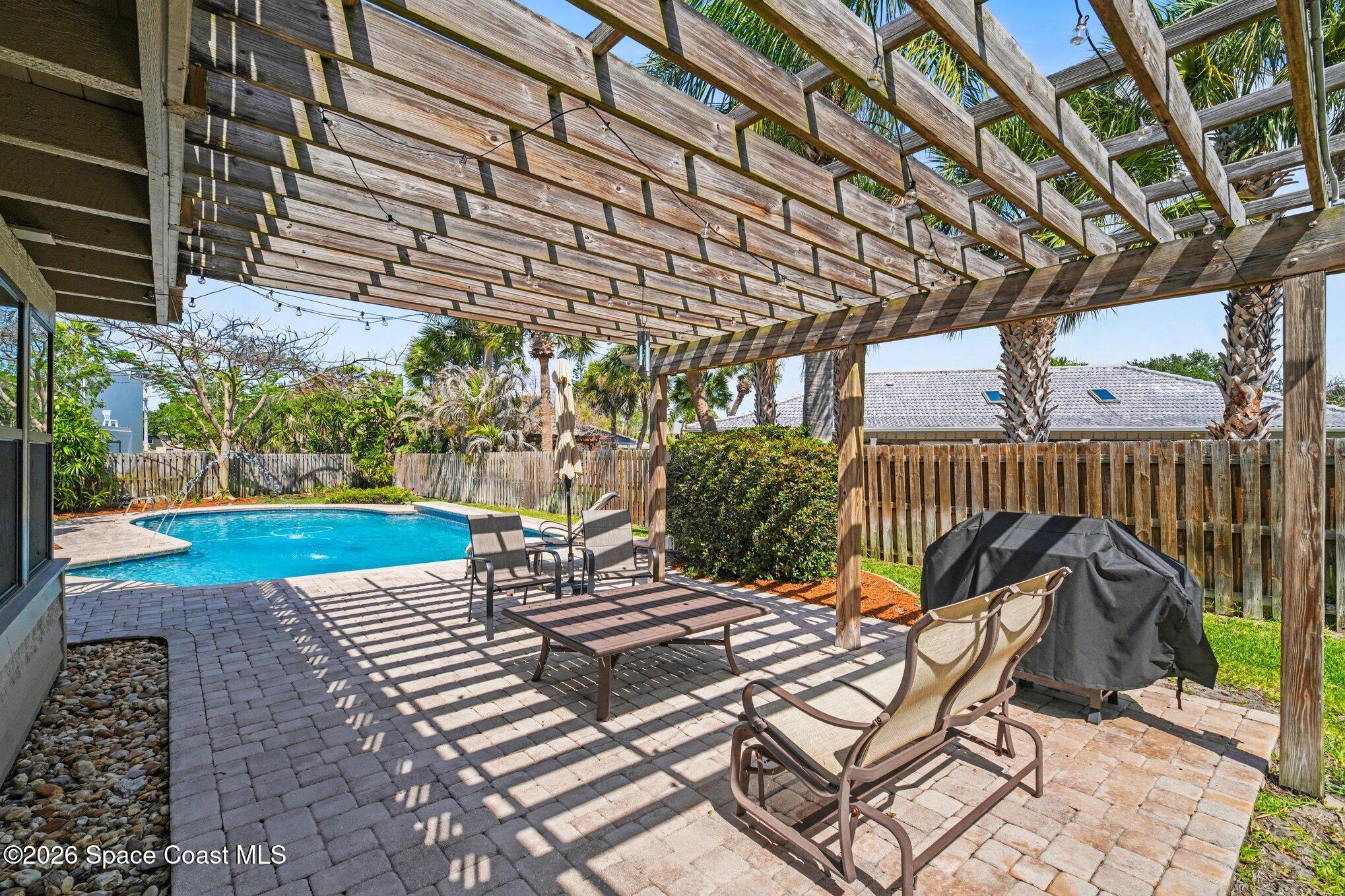 568 Rio Casa Drive North Indialantic, FL 32903 - Photo 36 of 45 a view of a patio with table and chairs with wooden floor and fence with plants and trees