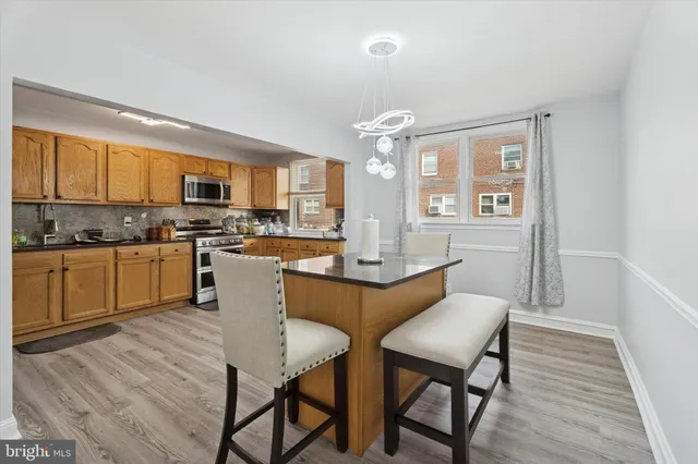 a kitchen with a table chairs microwave and cabinets