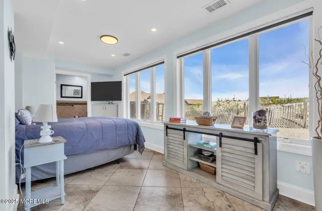 a large bedroom with a large bed and large windows