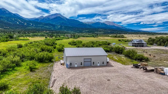 a view of a house with a yard and a large tree