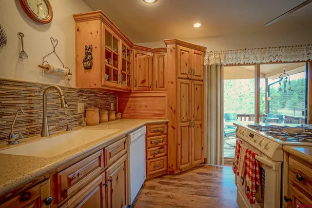 a kitchen with stainless steel appliances granite countertop a sink and a refrigerator