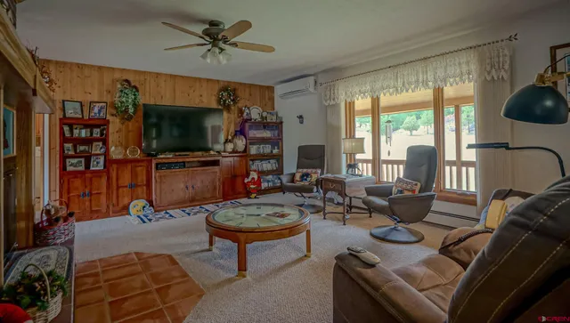 a living room with furniture a flat screen tv and a large window