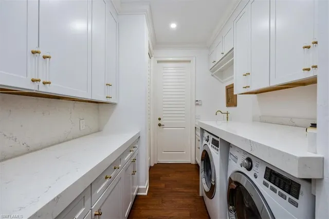 a utility room with cabinets washer and dryer