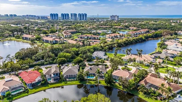 an aerial view of residential houses with outdoor space and lake view