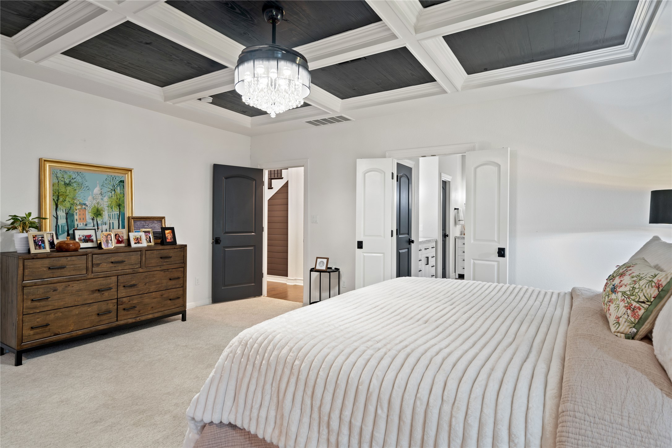 2829 Long Lasso Pass Leander, TX 78641 - Photo 19 of 40 a spacious bedroom with a bed and a chandelier