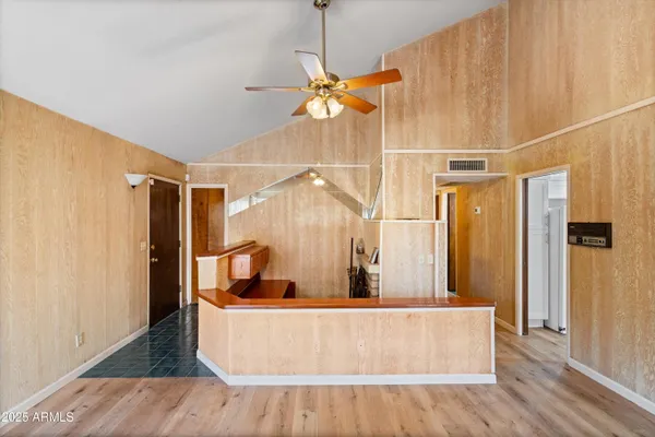 a living room with large mirror and a wooden floor