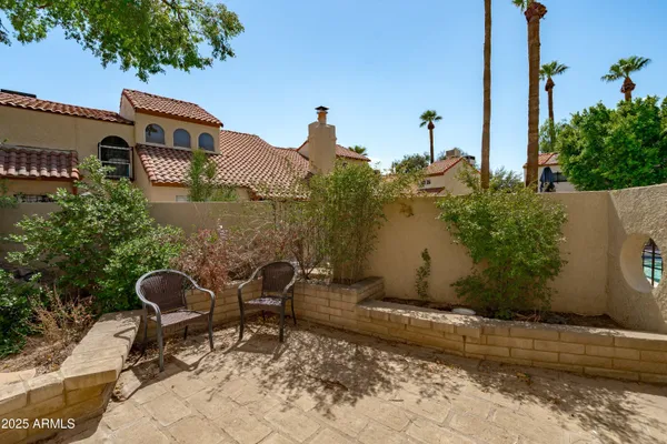 a backyard of a house with wooden fence and a bench